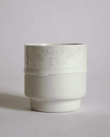 A white glaze porcelain stackable cup for morning coffee on white backgrround.