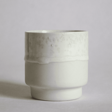 A white glaze porcelain stackable cup for morning coffee on white backgrround.